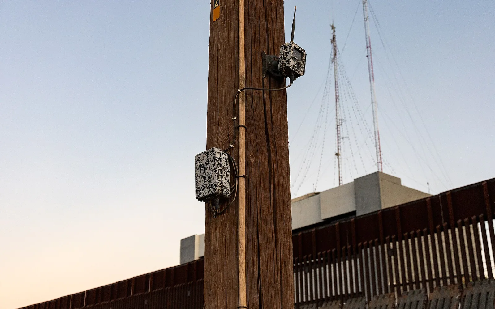 Border fencing and a pole-mounted camera at the U.S.–Mexico boundary in Calexico.